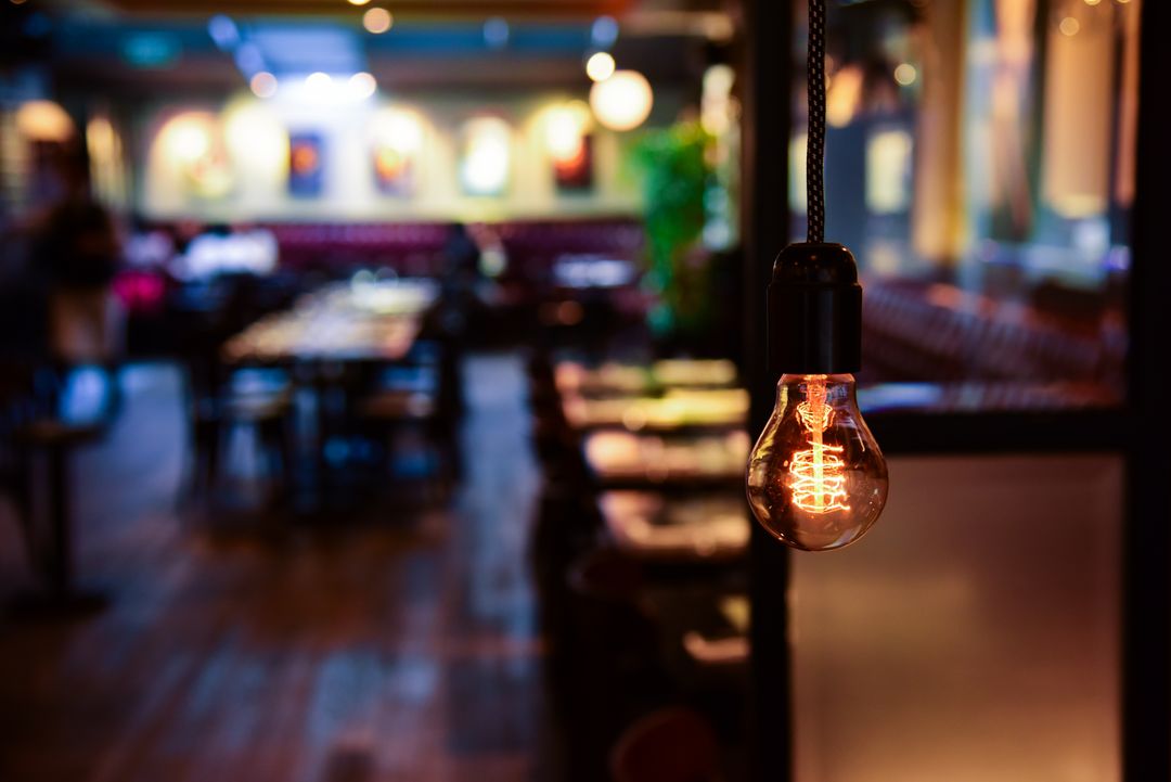 Empty Restaurant with Warm Light Bulb in Foreground - Free Images, Stock Photos and Pictures on Pikwizard.com