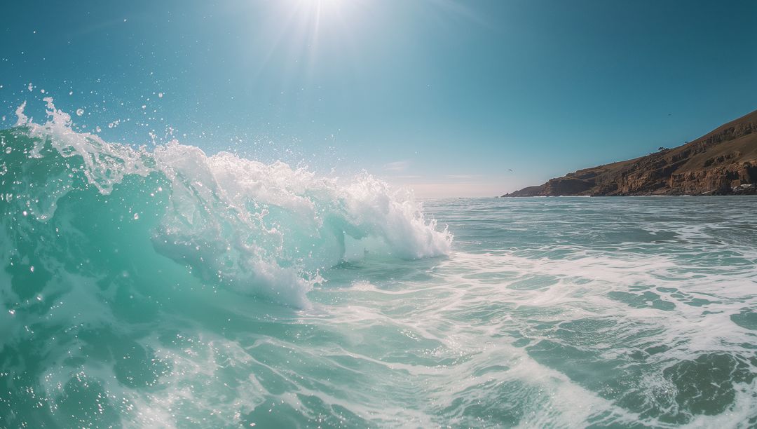 Turquoise Ocean Wave Crashing Under Sunlight with White Foam