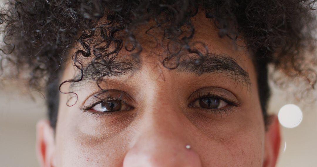 Close-up of Eyes and Curly Hair of a Person with Nose Piercing - Free Images, Stock Photos and Pictures on Pikwizard.com