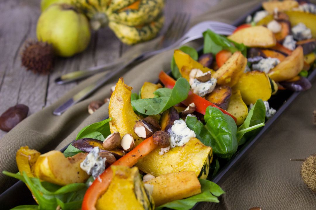 Showcasing roasted autumn squash and spinach salad with blue cheese, nuts, and peppers