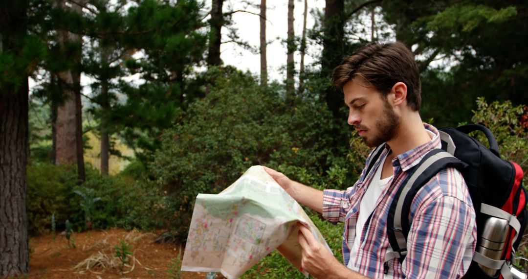 Male Hiker Reading Map in Forest - Free Images, Stock Photos and Pictures on Pikwizard.com