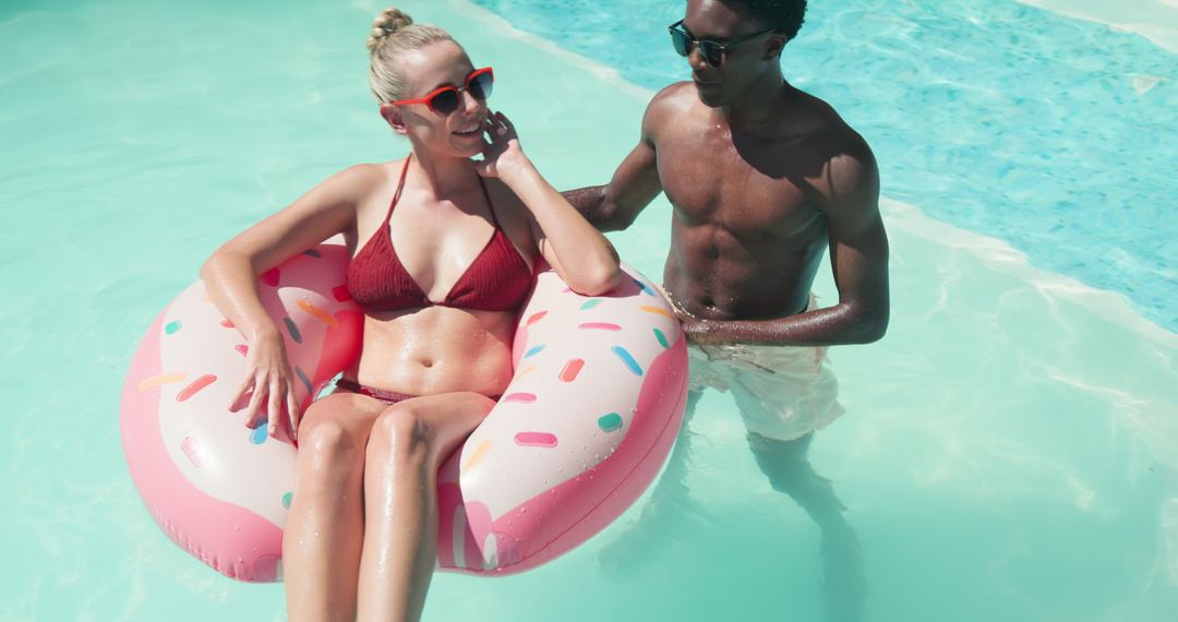 Diverse Couple Enjoying Pool Relaxation on Donut Float