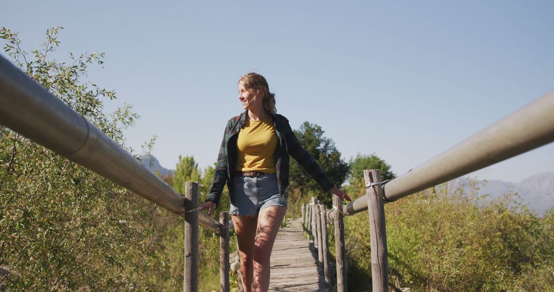 Woman Enjoying Nature Walk on Wooden Bridge in Park - Free Images, Stock Photos and Pictures on Pikwizard.com