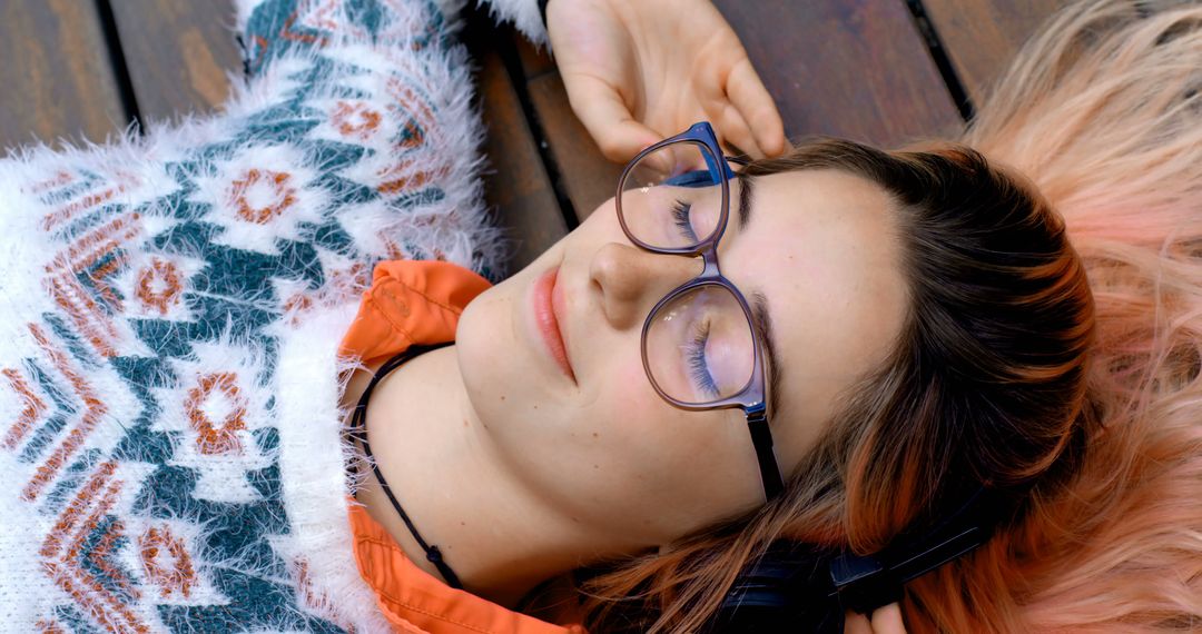 Young Woman Relaxing on Wooden Deck Listening to Music - Free Images, Stock Photos and Pictures on Pikwizard.com