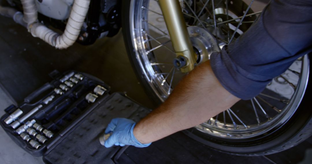 Mechanic Repairing Motorcycle Wheel in Workshop - Free Images, Stock Photos and Pictures on Pikwizard.com