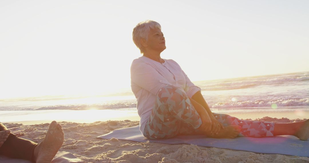 Senior Woman Practicing Yoga on Beach at Sunrise - Free Images, Stock Photos and Pictures on Pikwizard.com