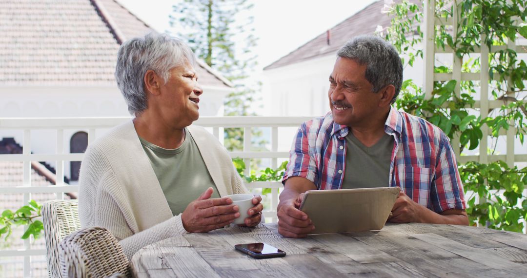 Elderly couple enjoying coffee on patio, engaging in conversation - Free Images, Stock Photos and Pictures on Pikwizard.com