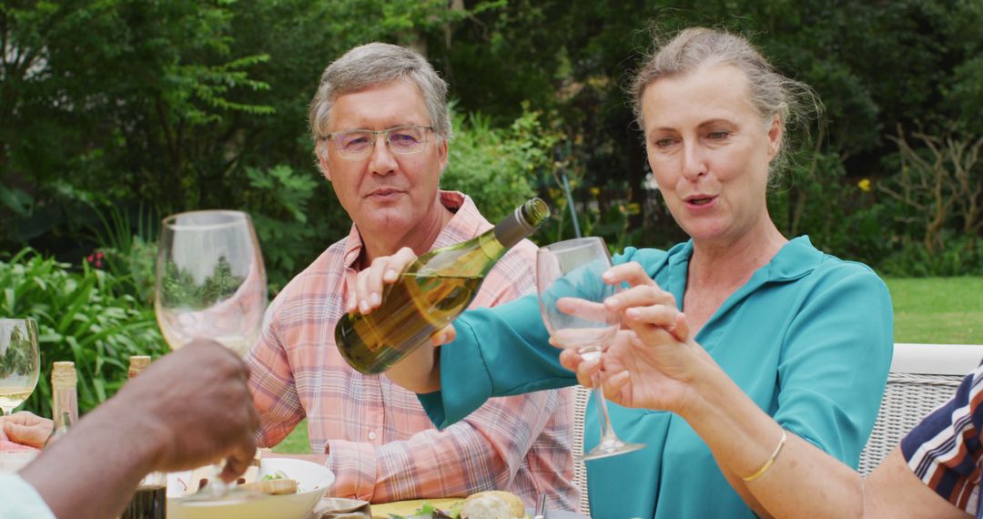 Mature friends enjoying outdoor wine tasting gathering - Free Images, Stock Photos and Pictures on Pikwizard.com