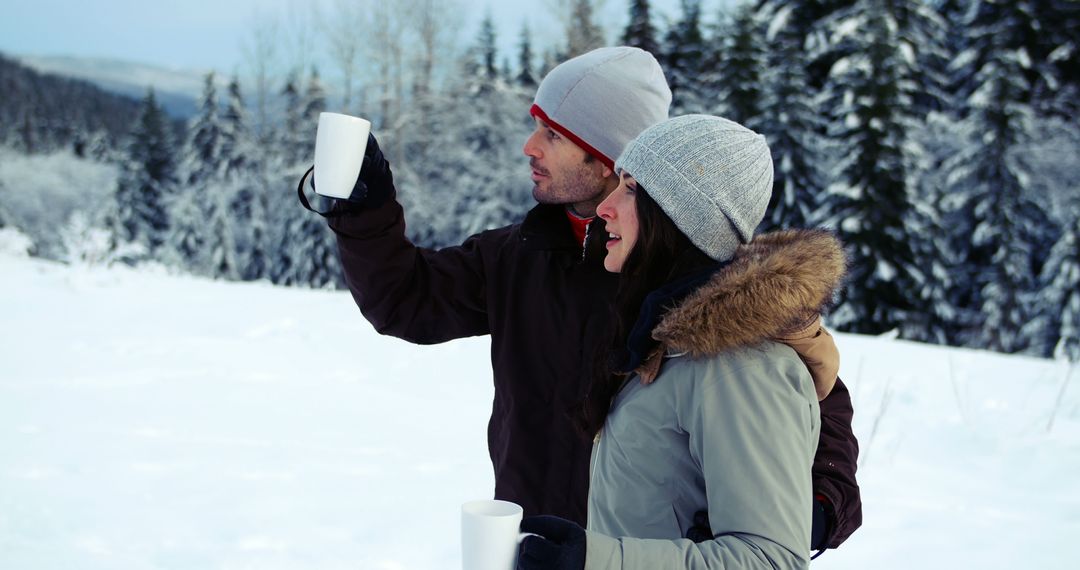 Couple Enjoying Warm Drinks in Winter Forest Landscape - Free Images, Stock Photos and Pictures on Pikwizard.com