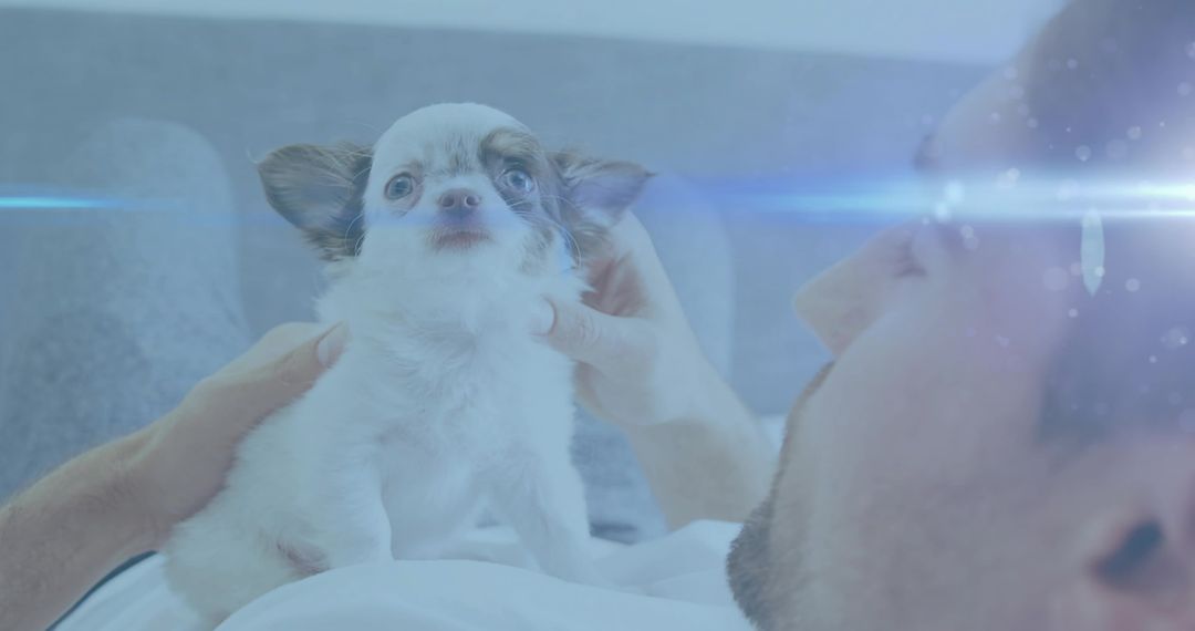 Relaxing Man Cradling Tiny Puppy in Cozy Home Setting