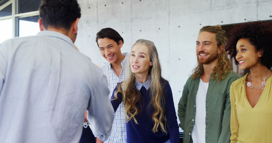 Diverse Group Engaging in Friendly Conversation in Modern Office