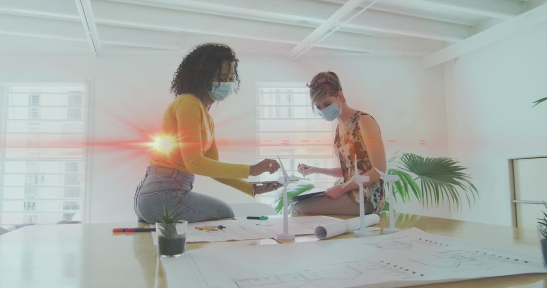 Businesswomen Collaborating on Project While Wearing Masks in Office