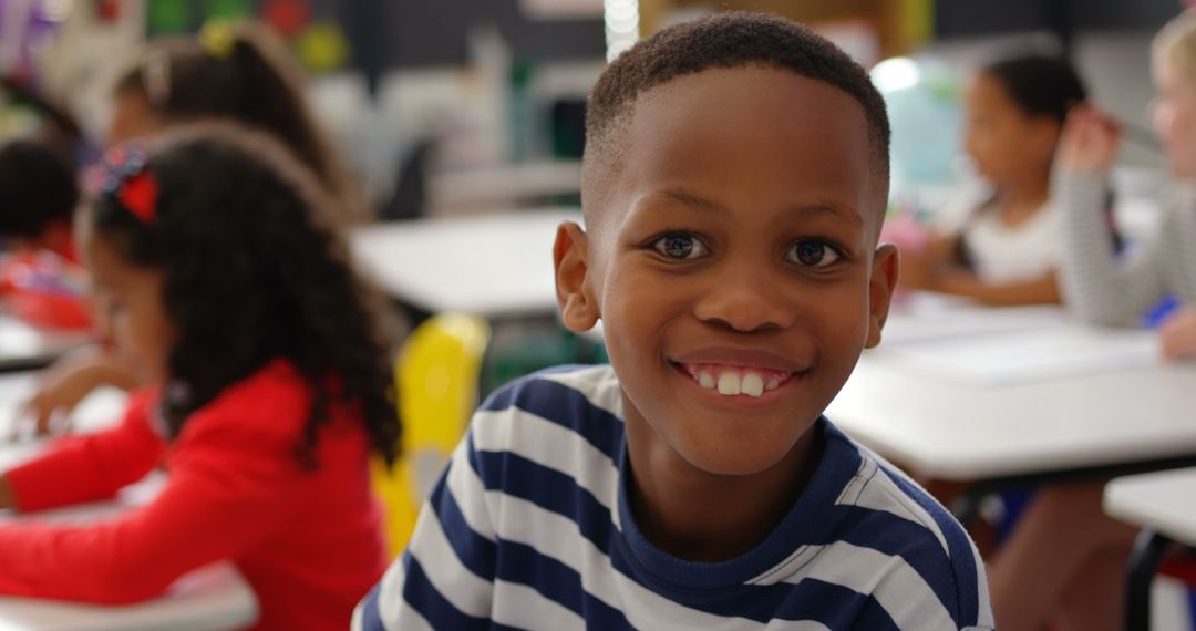 Smiling Boy in Classroom Setting with Diverse Classmates