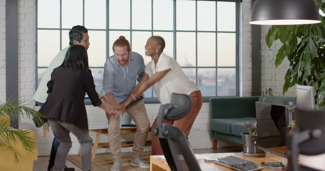 Celebrating Success Diverse Team Joining Hands in Office
