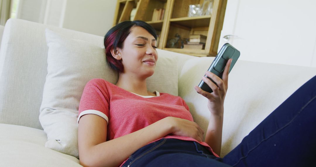 Relaxed Woman Using Smartphone on Couch at Home - Free Images, Stock Photos and Pictures on Pikwizard.com