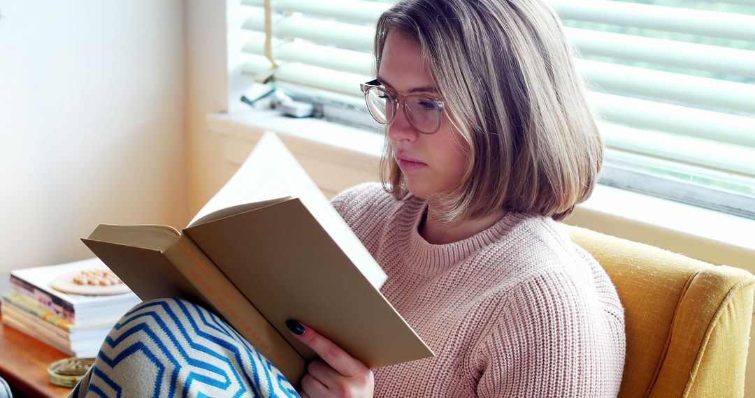 Young Woman Reading Book Near Window - Free Images, Stock Photos and Pictures on Pikwizard.com