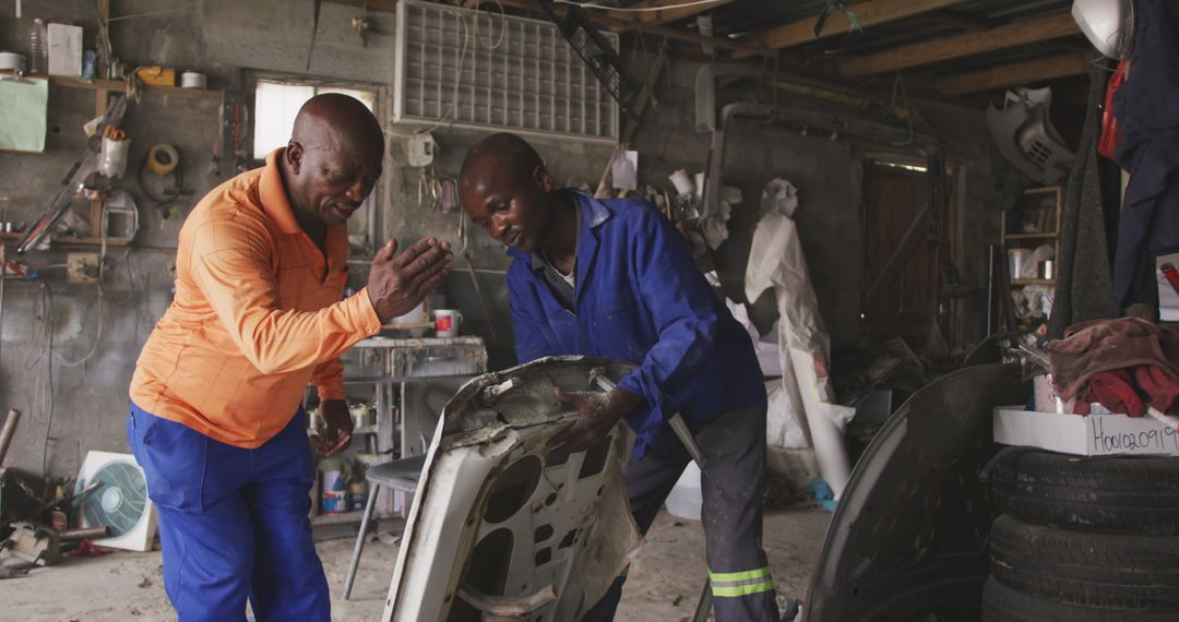 Two Auto Mechanics Working on Car Parts in Garage Workshop - Free Images, Stock Photos and Pictures on Pikwizard.com