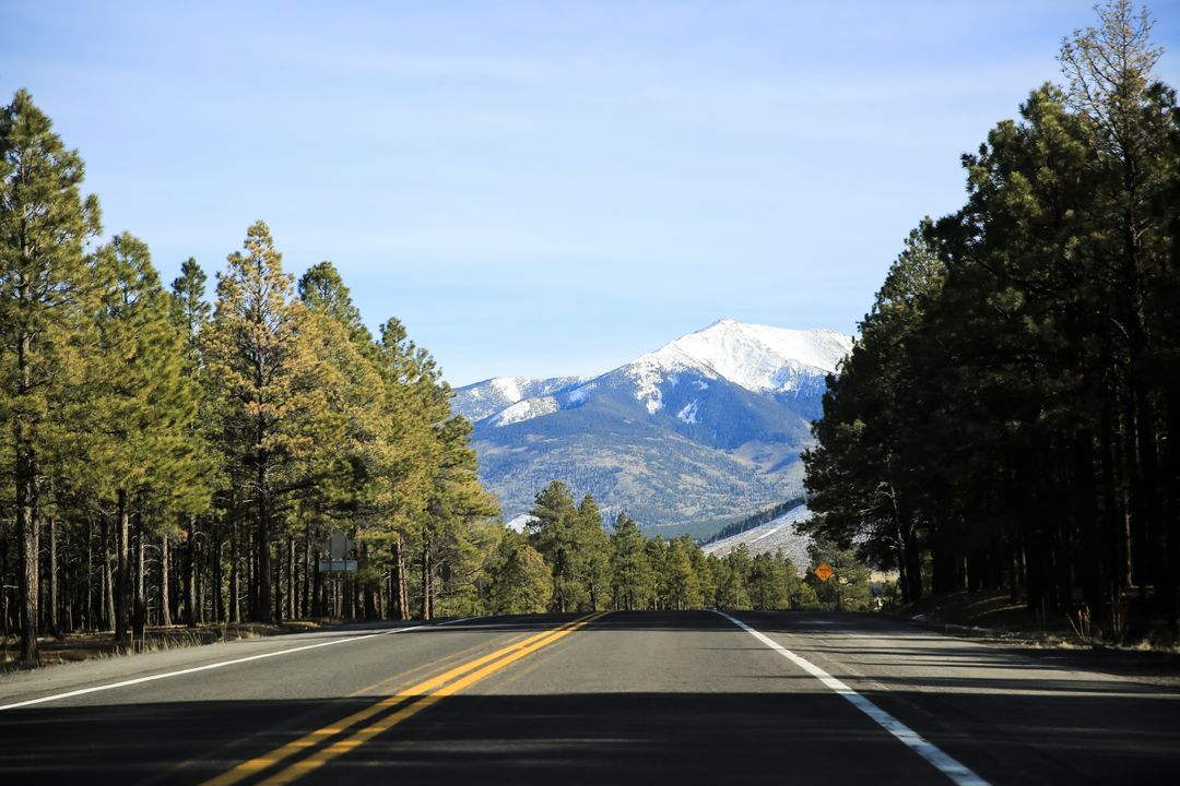 Scenic Drive on Mountain Road with Snow-Capped Peaks in Distance - Free Images, Stock Photos and Pictures on Pikwizard.com
