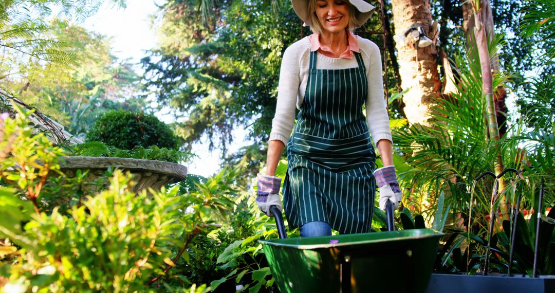 Woman Gardener with Wheelbarrow in Lush Green Garden Under Bright Sun - Free Images, Stock Photos and Pictures on Pikwizard.com