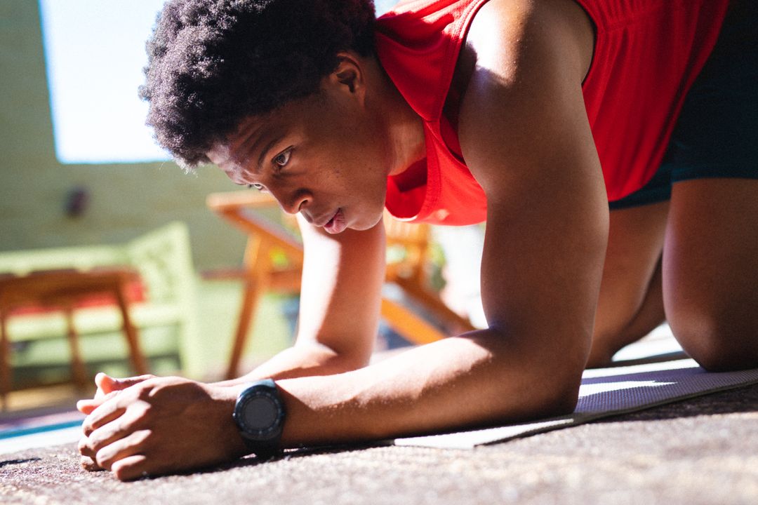 Close-up of african american young man kneeling while exercising at home - Free Images, Stock Photos and Pictures on Pikwizard.com