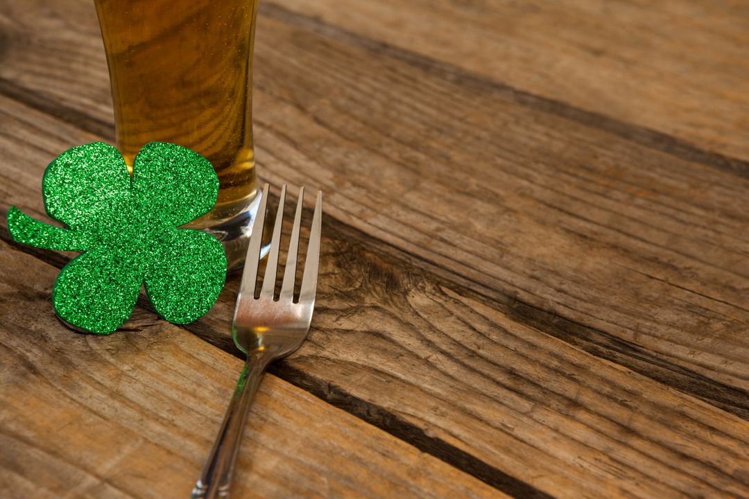 Glass of beer, fork and shamrock for St Patricks Day - Free Images, Stock Photos and Pictures on Pikwizard.com
