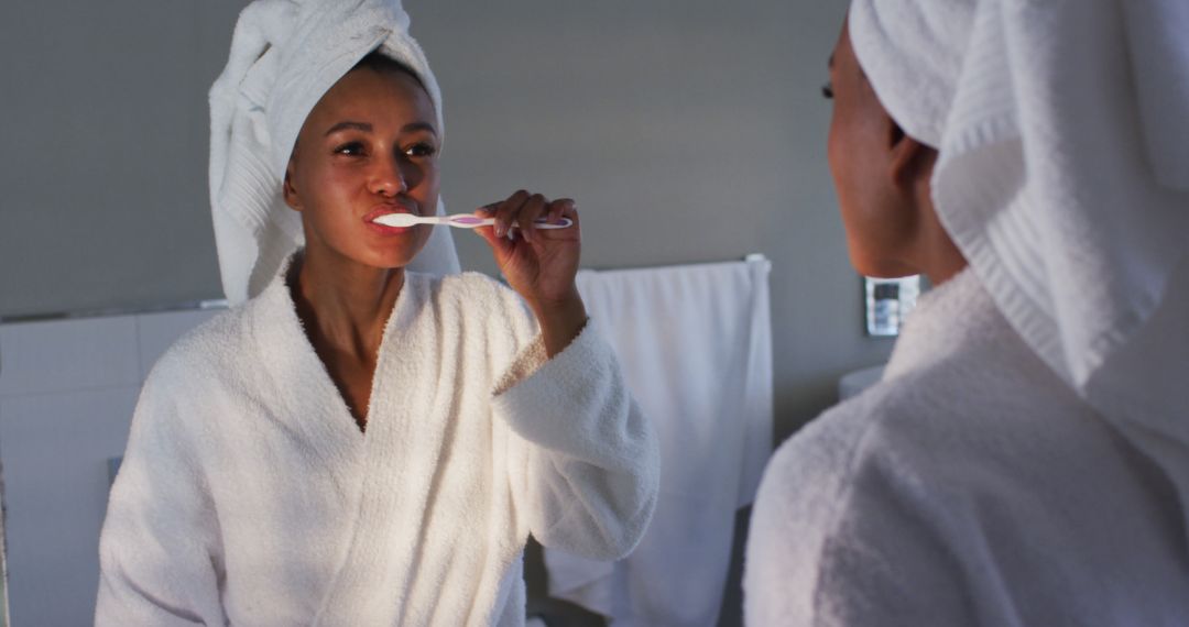 Woman Brushing Teeth in Bathroom Mirror Reflection - Free Images, Stock Photos and Pictures on Pikwizard.com