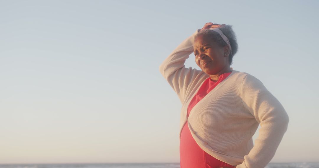 Senior Woman Looking Pensive at Beach During Sunset - Free Images, Stock Photos and Pictures on Pikwizard.com