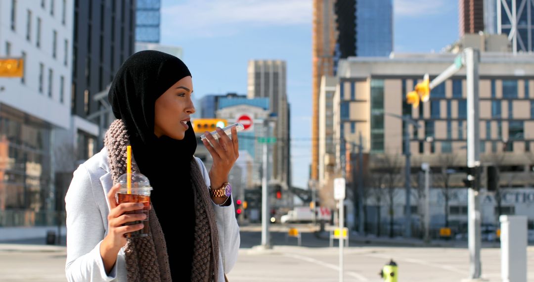 Young Woman in Hijab Drinking Iced Coffee and Talking on Phone in City - Free Images, Stock Photos and Pictures on Pikwizard.com