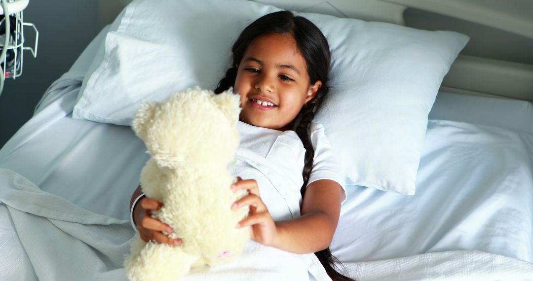 Smiling Child with Teddy Bear on Hospital Bed - Free Images, Stock Photos and Pictures on Pikwizard.com