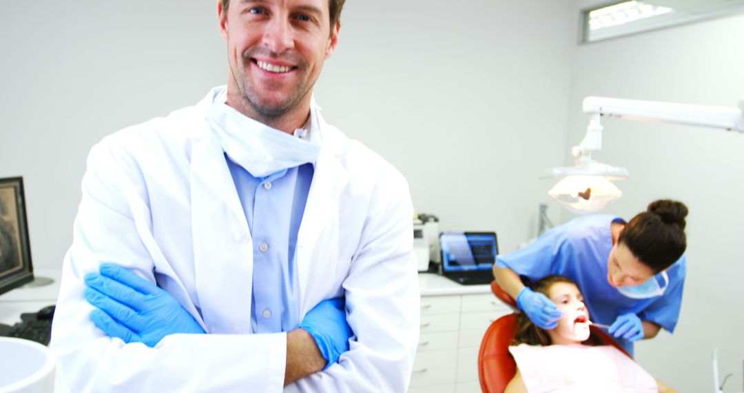 Confident Dentist Standing in Modern Dental Clinic with Nurse Treating Patient - Free Images, Stock Photos and Pictures on Pikwizard.com