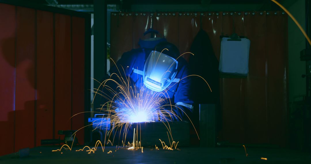 Welder Wearing Mask Working With Sparks Flying in Workshop - Free Images, Stock Photos and Pictures on Pikwizard.com