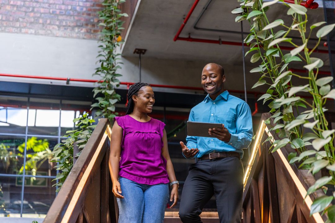 Coworkers Discussing Project in Modern Eco-Friendly Office Atrium