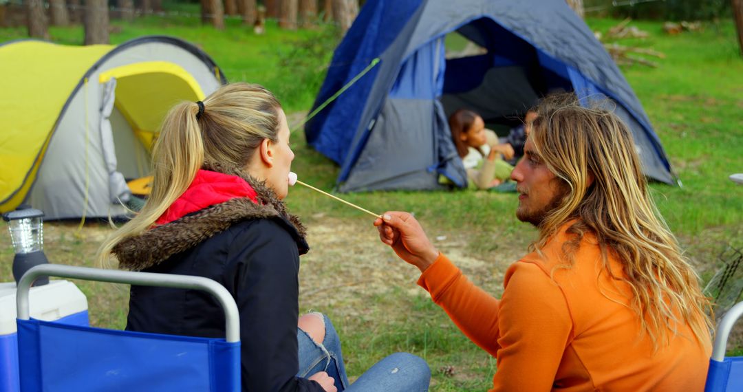 Couple Enjoying Marshmallows by Campfire in Forest