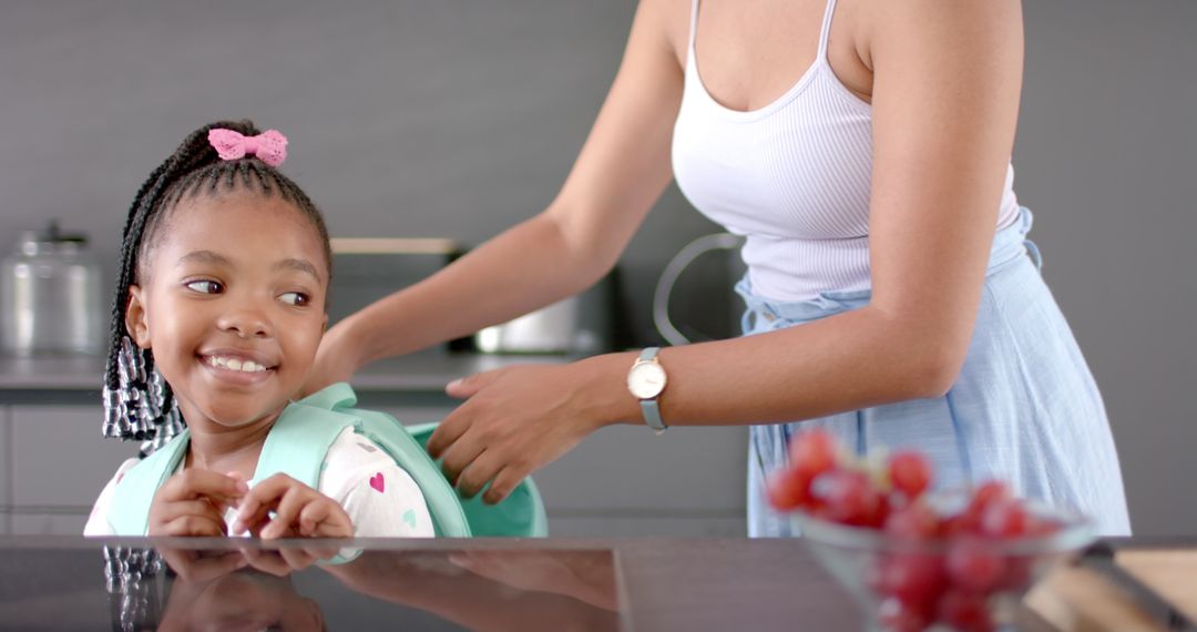 Mother Assisting Daughter with Backpack in Modern Kitchen