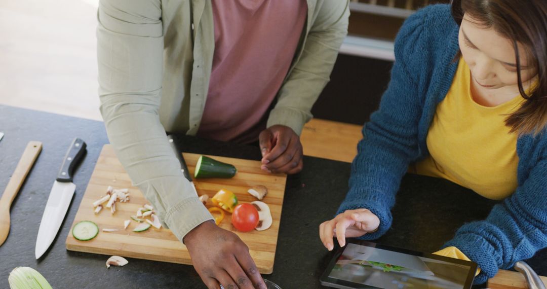 Diverse Couple Cooking Together, Using Tablet for Recipe in Kitchen