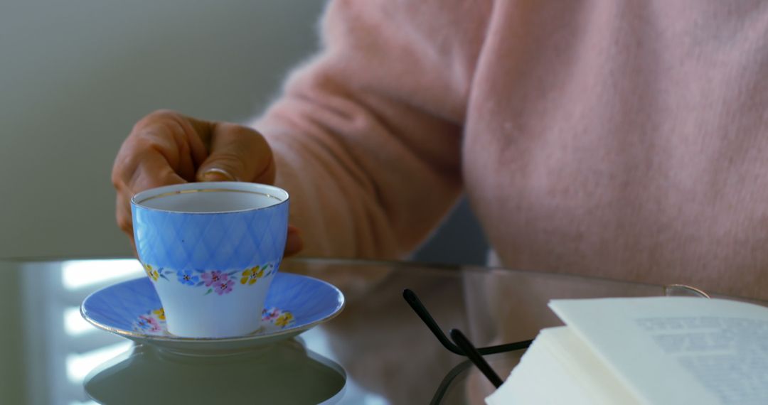 Person Enjoying Tea Time with Blue Floral Teacup and Saucer - Free Images, Stock Photos and Pictures on Pikwizard.com