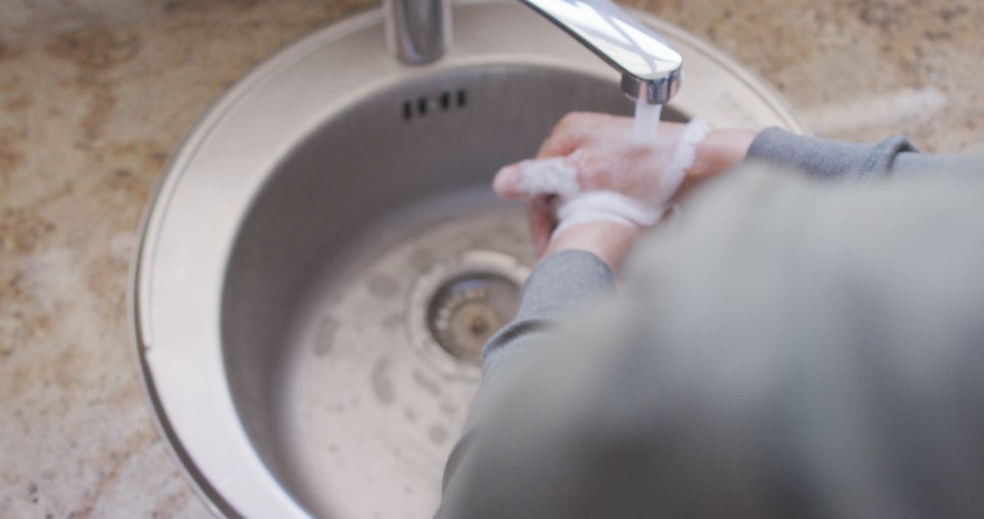 Person Washing Hands with Soap at Kitchen Sink for Hygiene - Free Images, Stock Photos and Pictures on Pikwizard.com