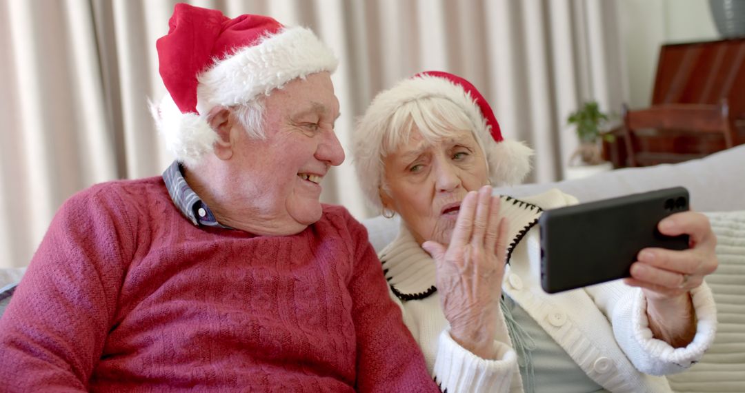 Senior Couple in Santa Hats Video Calling on Smartphone - Free Images, Stock Photos and Pictures on Pikwizard.com