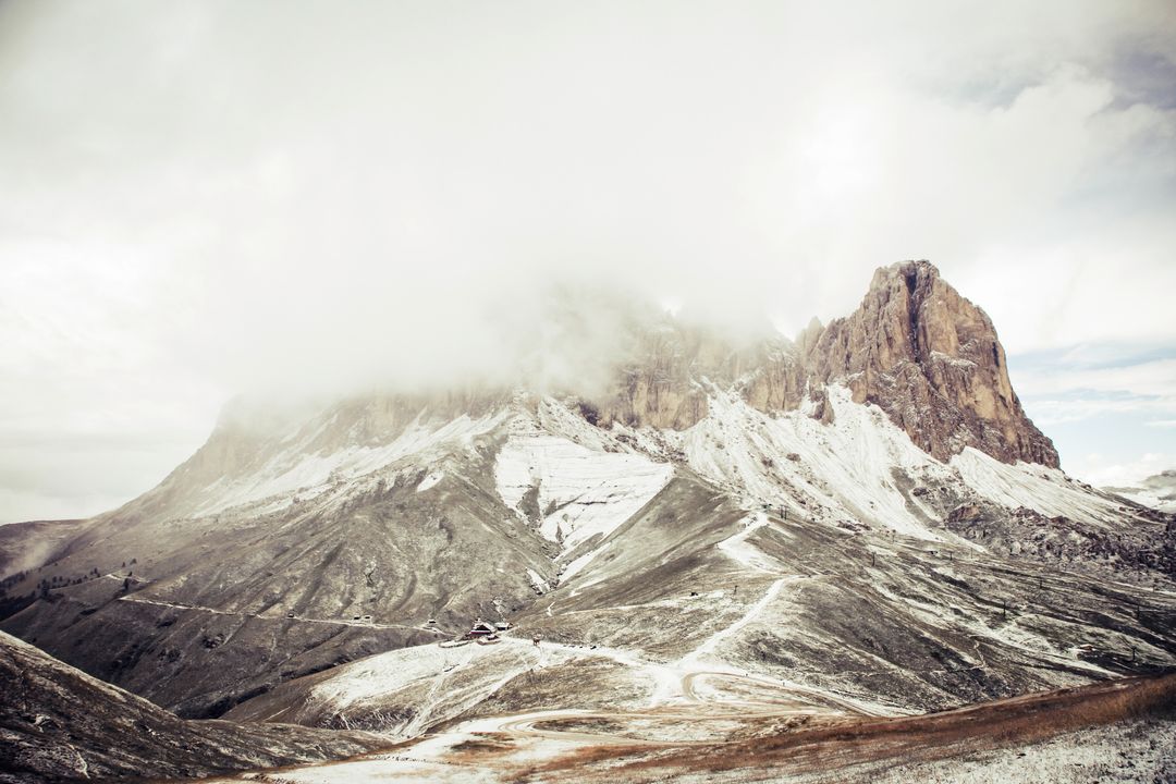 Misty Mountain Landscape with Snow Dusting and Winding Paths
