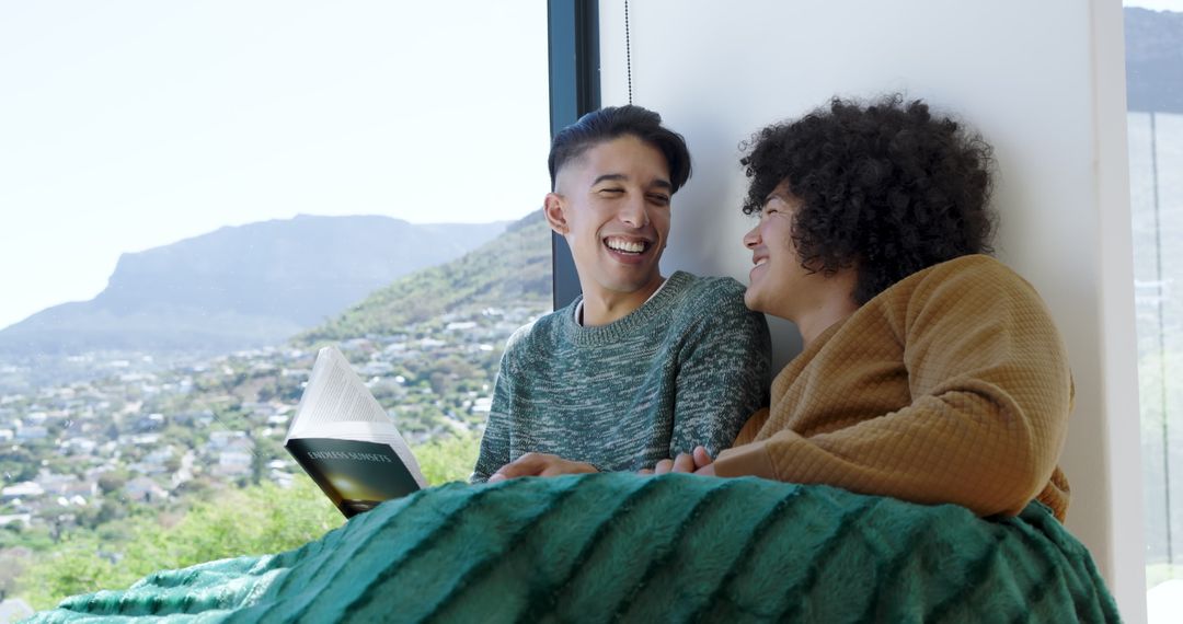 Couple Relaxing by Windowsill with Cozy Blanket and Book