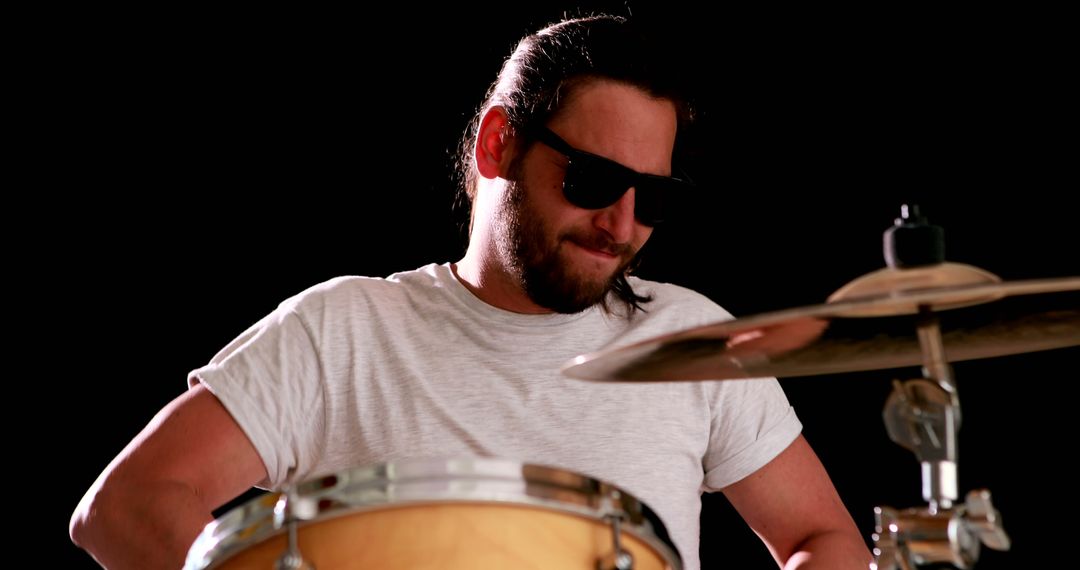 Drummer playing his drum kit on black background - Free Images, Stock Photos and Pictures on Pikwizard.com