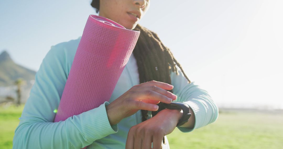 Young Woman Checking Fitness Tracker Before Outdoor Yoga Session - Free Images, Stock Photos and Pictures on Pikwizard.com