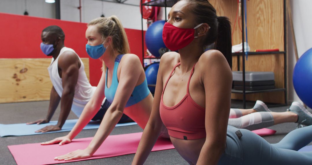 Diverse Group Practicing Yoga Wearing Masks in Fitness Studio - Free Images, Stock Photos and Pictures on Pikwizard.com