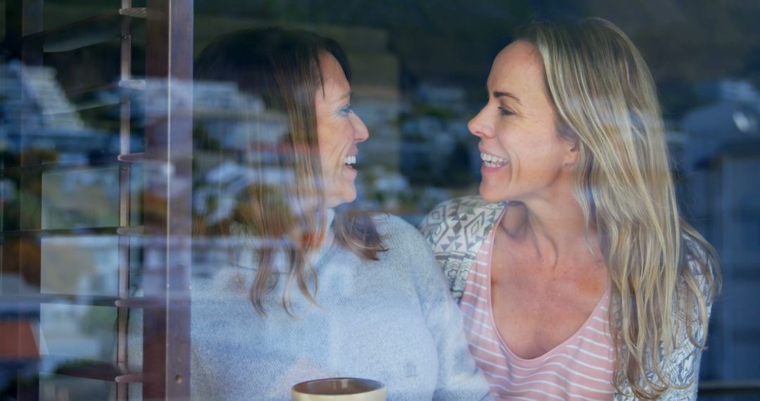 Happy Women Laughing Together through Window Reflection - Free Images, Stock Photos and Pictures on Pikwizard.com