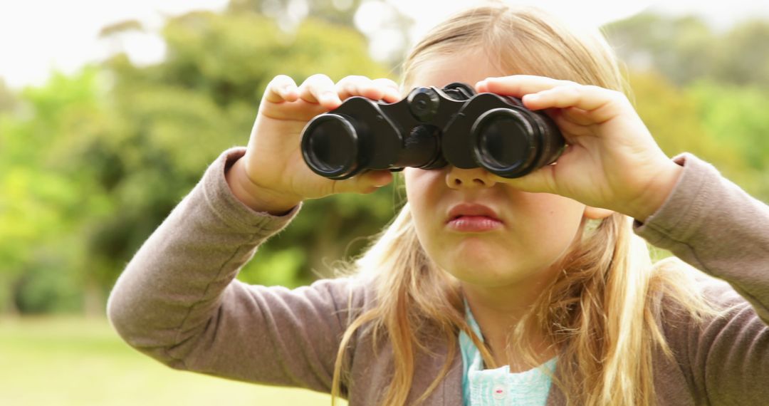 Curious Girl Exploring Nature with Binoculars in Green Park - Free Images, Stock Photos and Pictures on Pikwizard.com