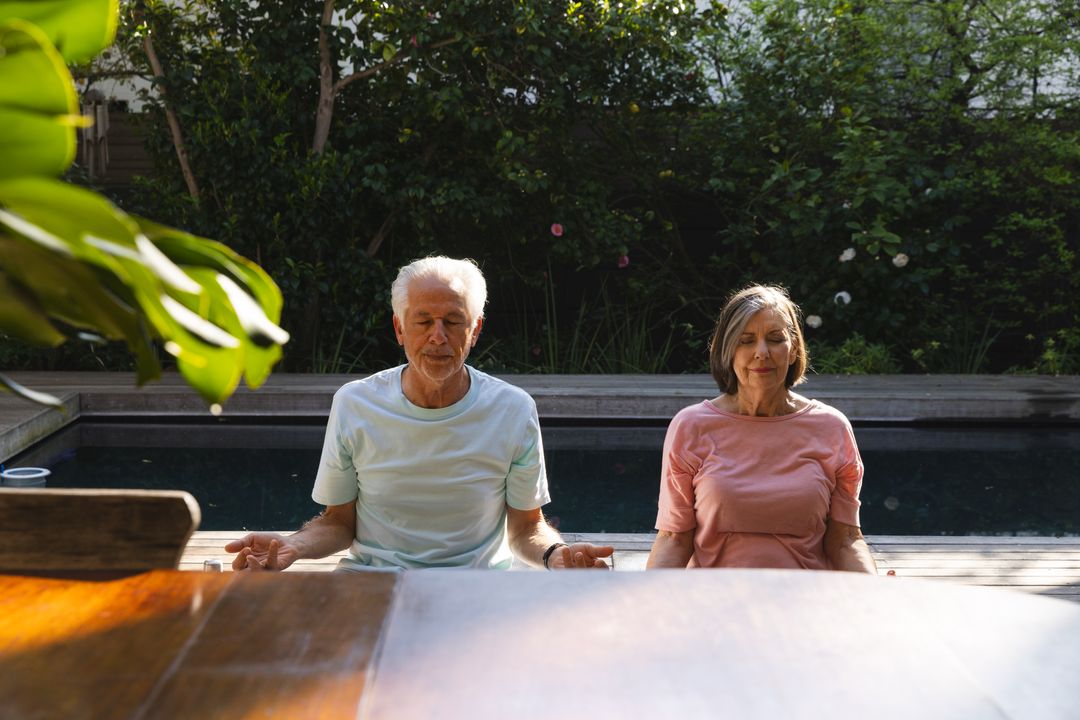 Senior Couple Meditating on Poolside Deck for Relaxation and Wellness