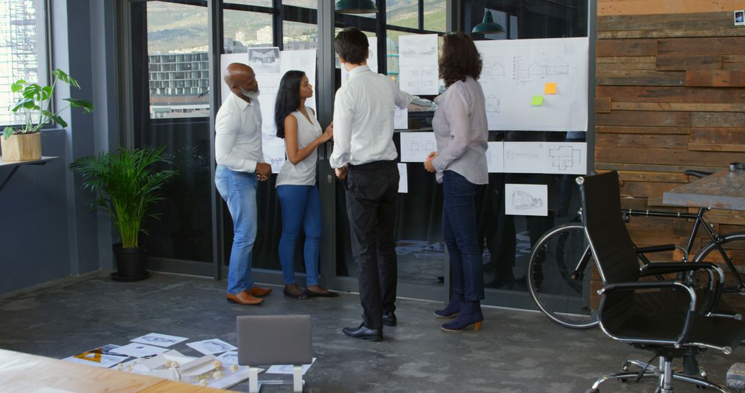 Team Discussing Blueprints During Office Meeting - Free Images, Stock Photos and Pictures on Pikwizard.com