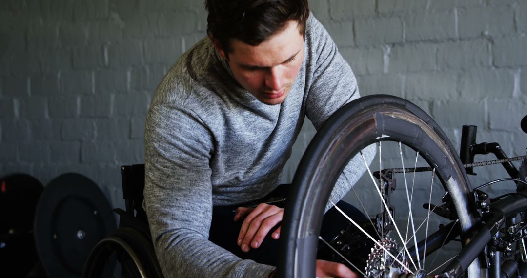 Man Repairing Wheelchair Tire with Focused Expression - Free Images, Stock Photos and Pictures on Pikwizard.com