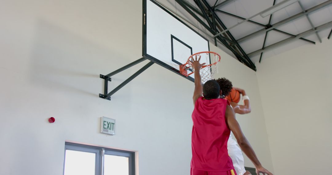 Intense Indoor Basketball Game Showing Powerful Slam Dunk