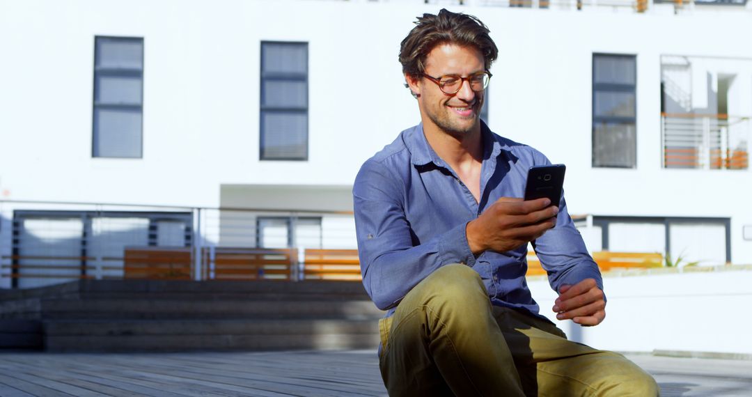 Smiling Man Texting On Smartphone Outdoors On Sunny Day - Free Images, Stock Photos and Pictures on Pikwizard.com